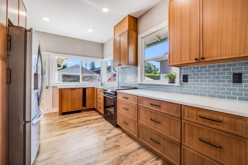 After Kitchen Remodel with Brown Wood Cabinets and Refrigerator in Seattle, WA by Kitchen & Bath Builders